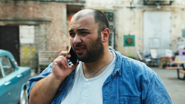 Man with a beard talking on the phone 