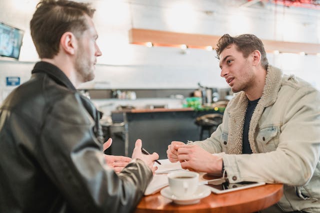 Two men sitting at a table having a conversation 